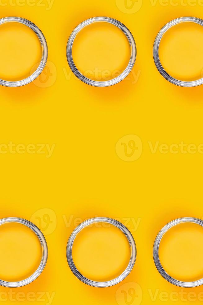 Yellow background with six paint jars. photo