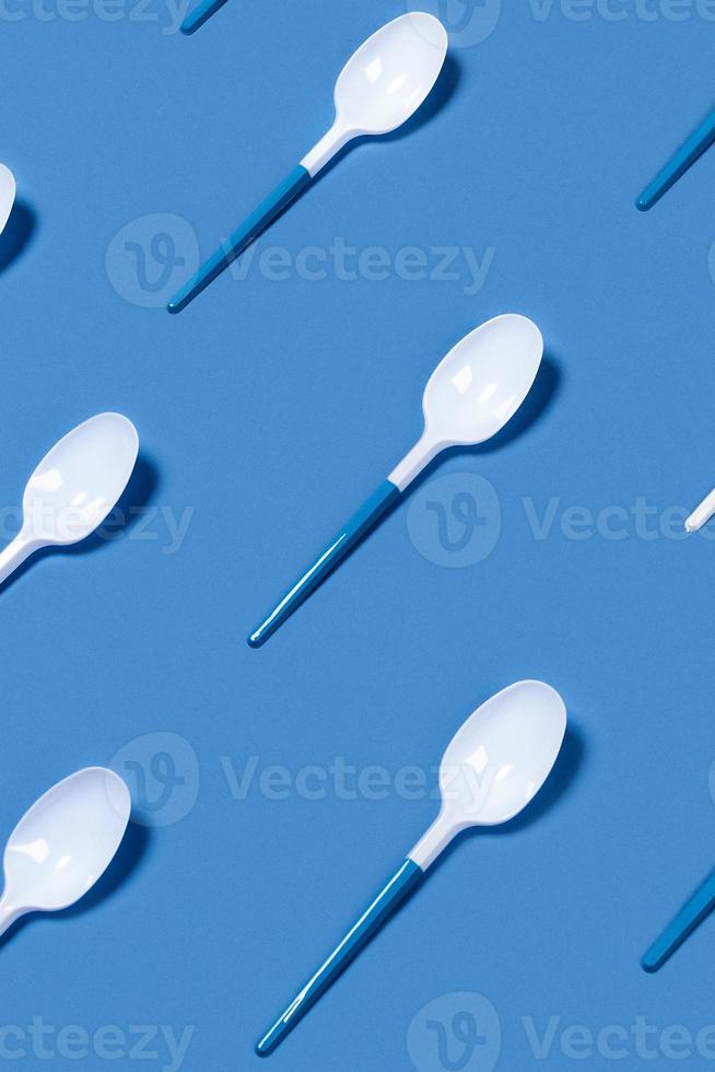 Pattern of white spoons on blue background. photo