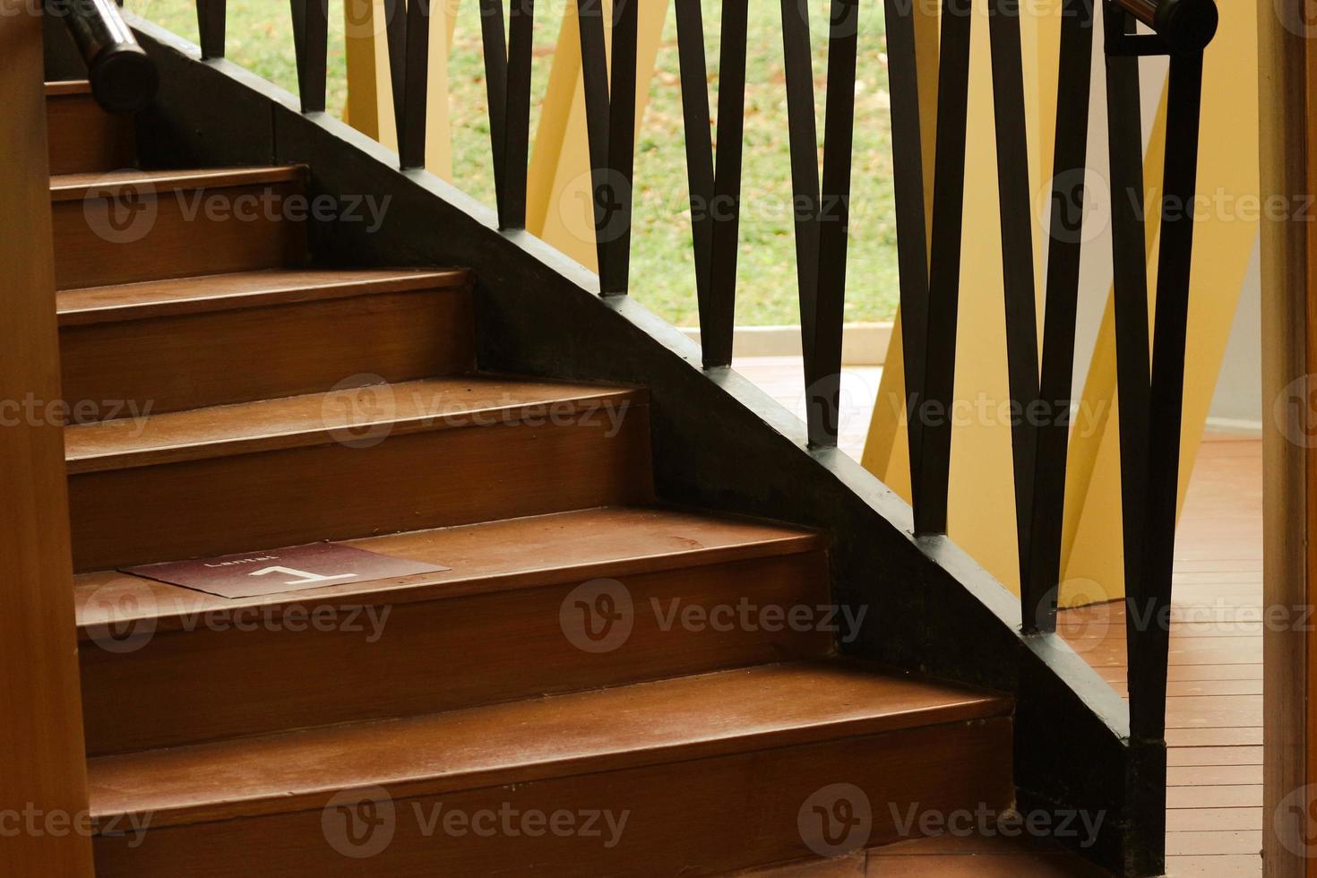 Wooden stairs with wooden railing in a building. photo