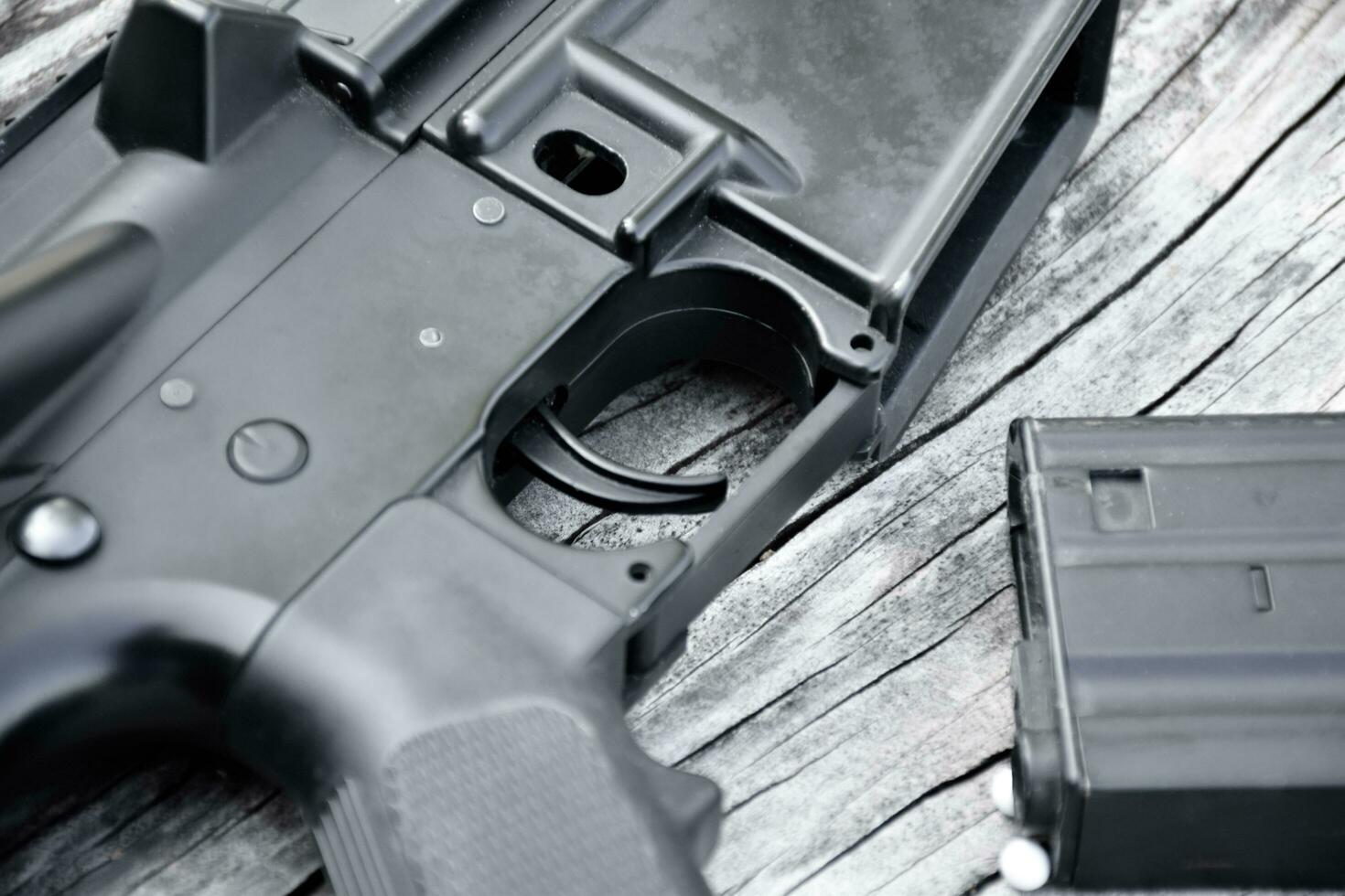 BB gun or airsoft gun muzzle and white bullets on wooden plank, soft and selective focus. photo