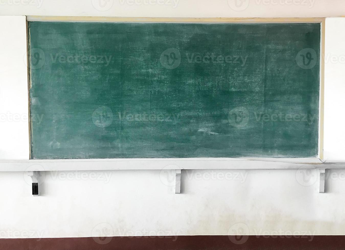 A blackboard for chalk are mounted on a white cement wall in a school classroom in a poor country in Asia. photo