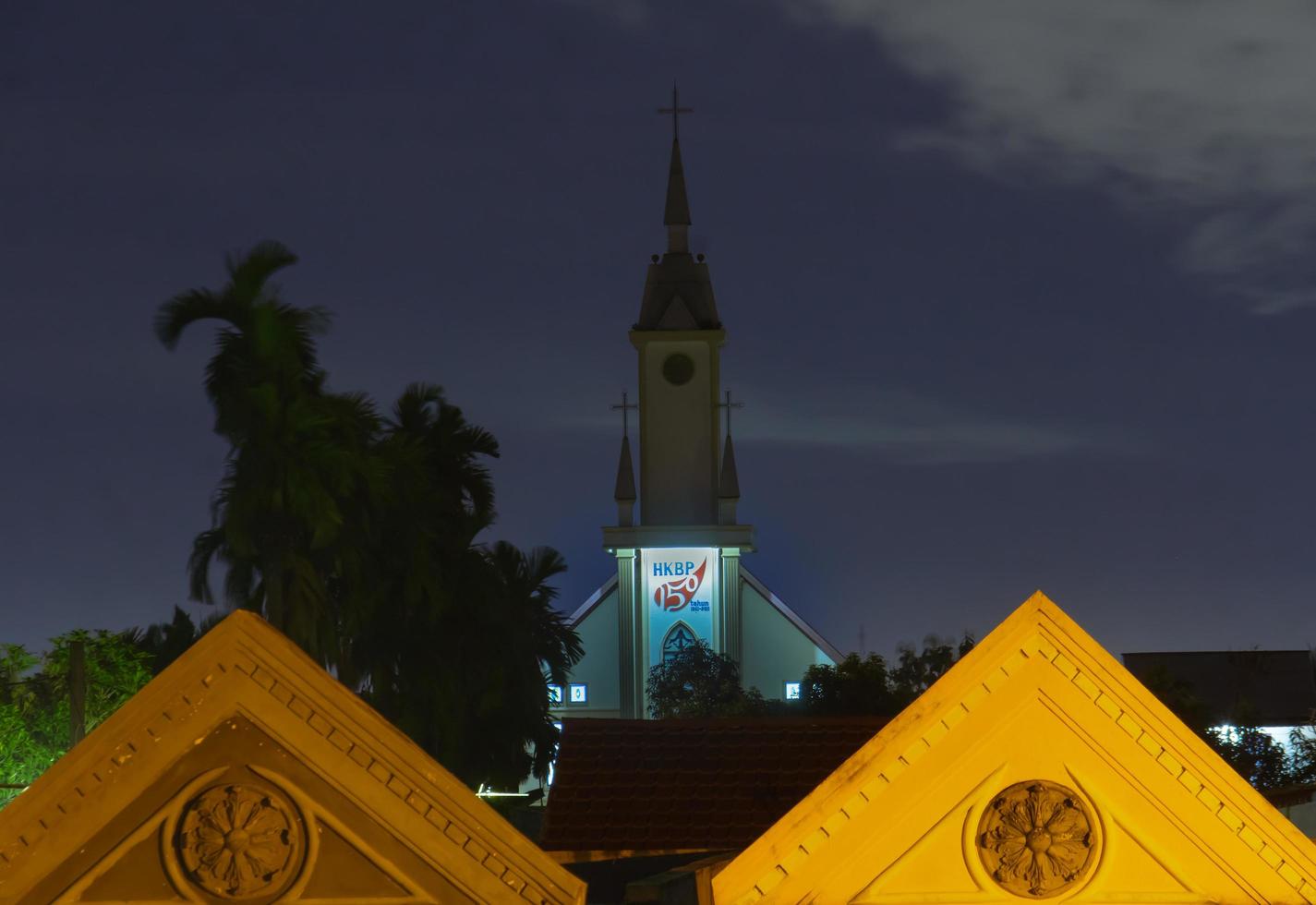 Medan,Indonesia - 2 December A HKBP or church tower, view from top building. Framing with roof of house photo