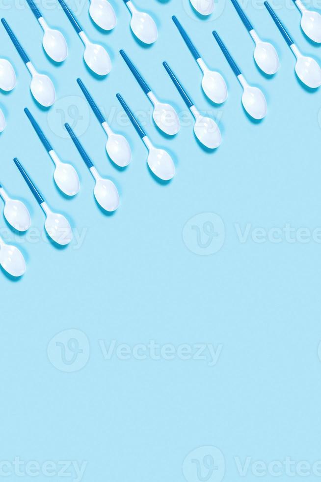 Picture of white plastic spoons on blue background. photo