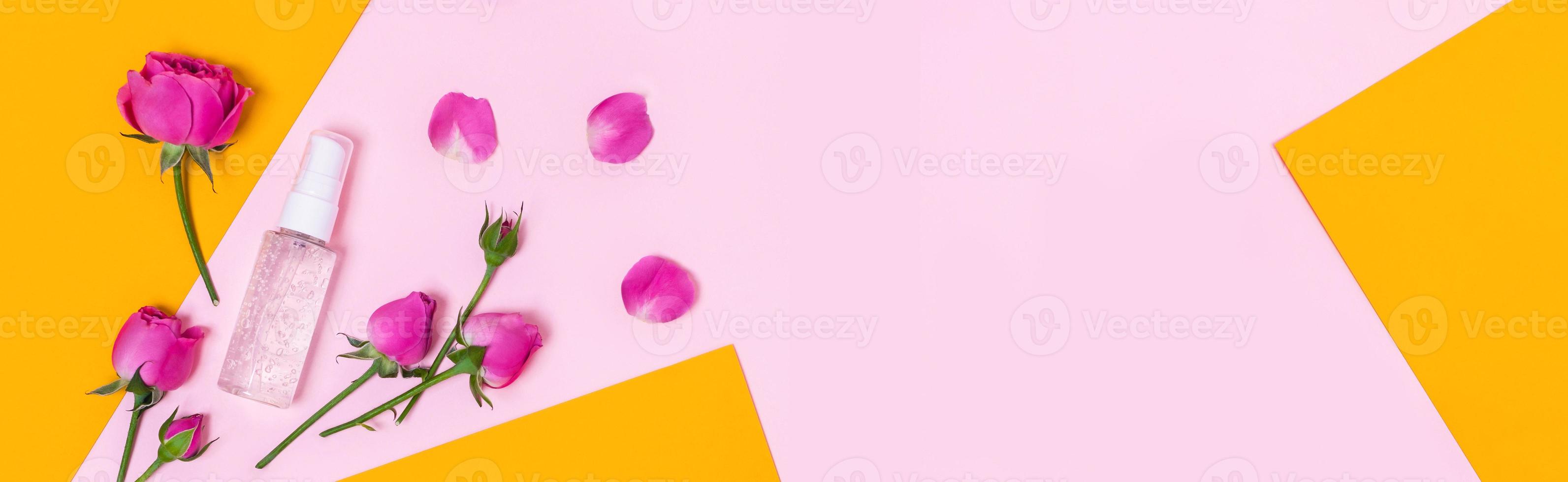 Yellow-pink background with a bottle and roses. photo