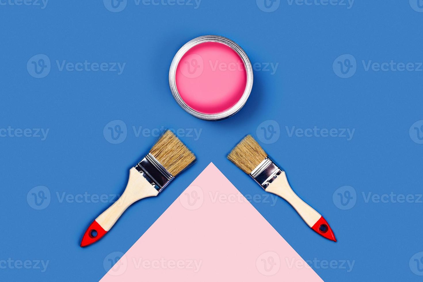 Two-toned background with pink paint jar and brushes. photo