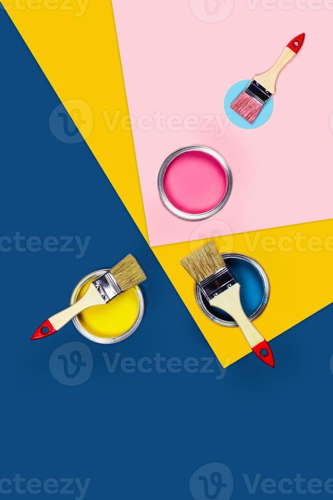 Three-colored background with paint jars and brushes. photo