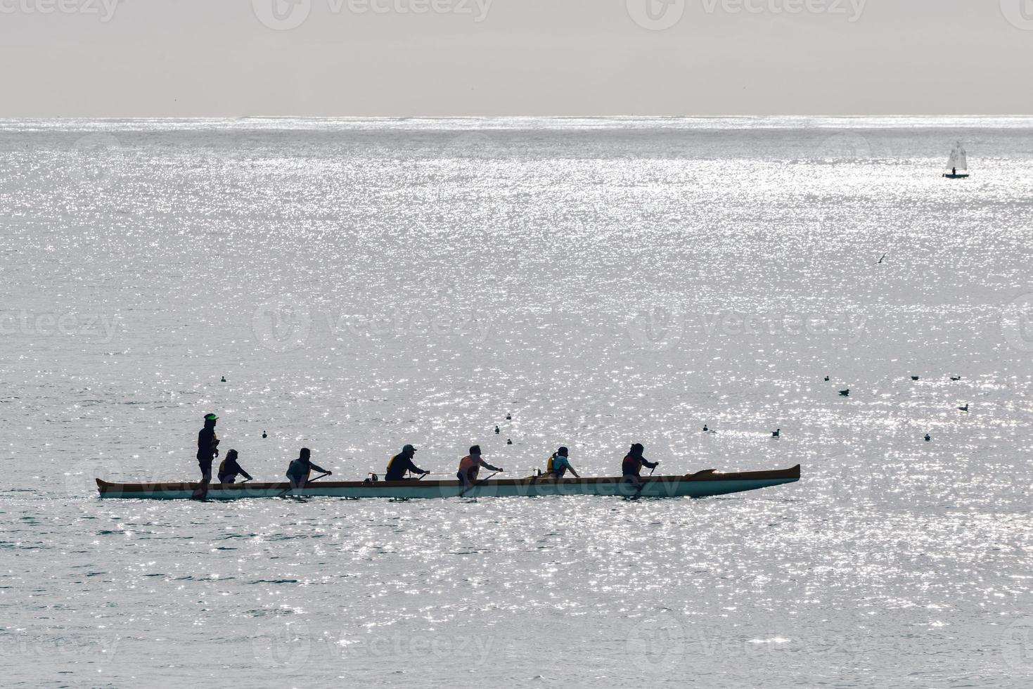 silhouette of people on a canoe at sunset photo