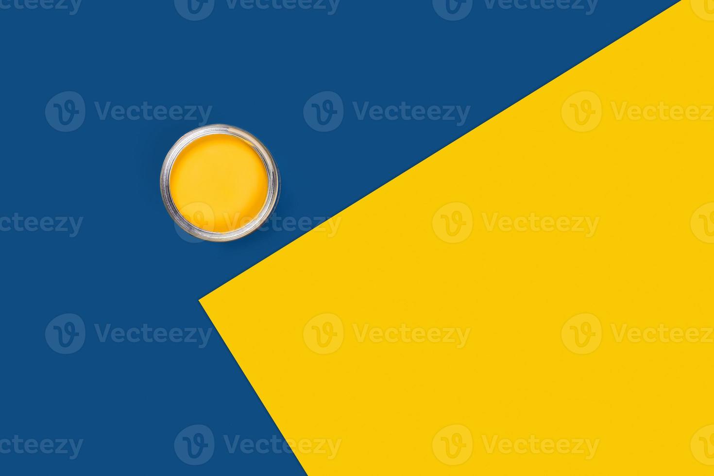 Two-toned background with yellow paint jar. photo