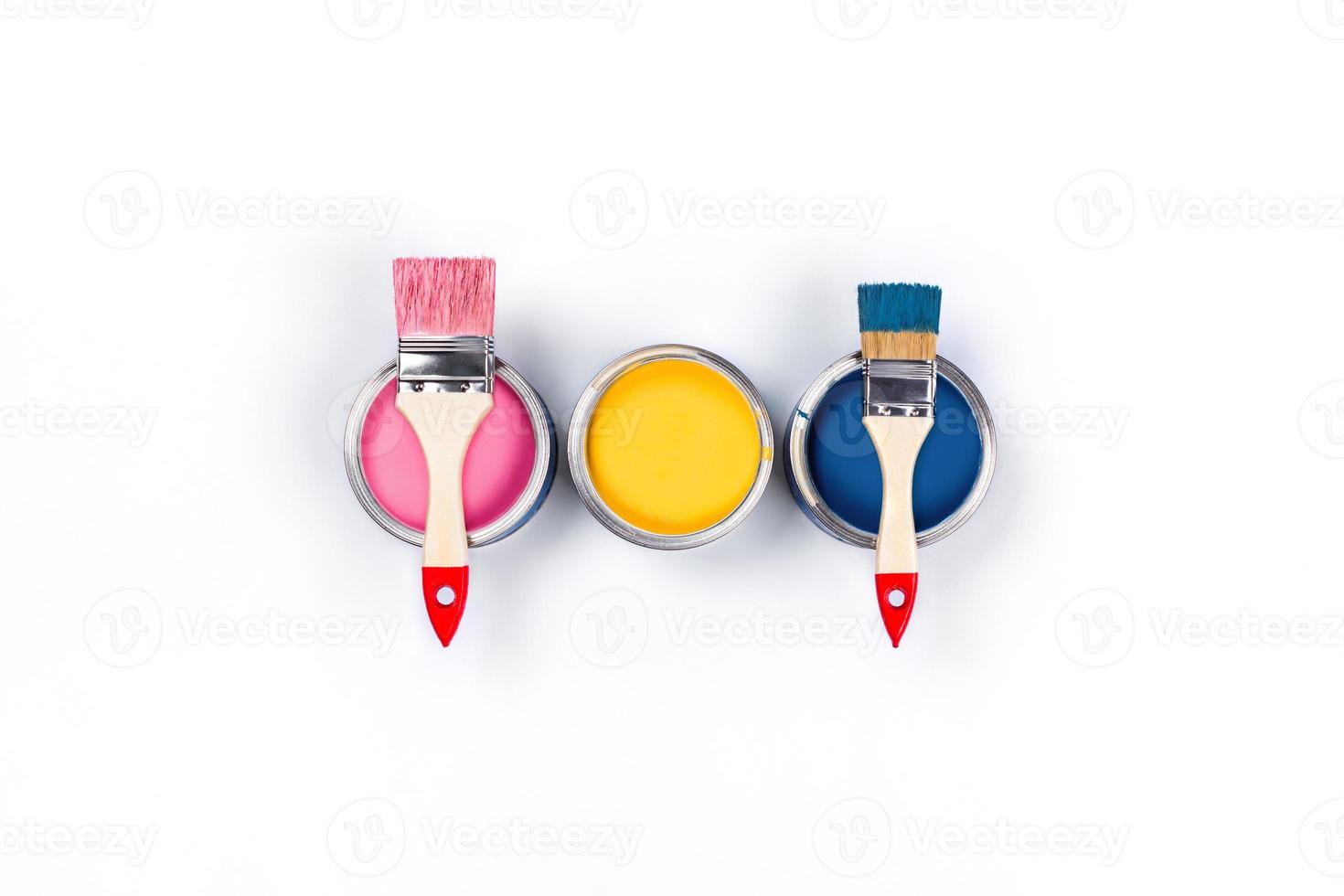 White background with three colored paint jars and brushes. photo