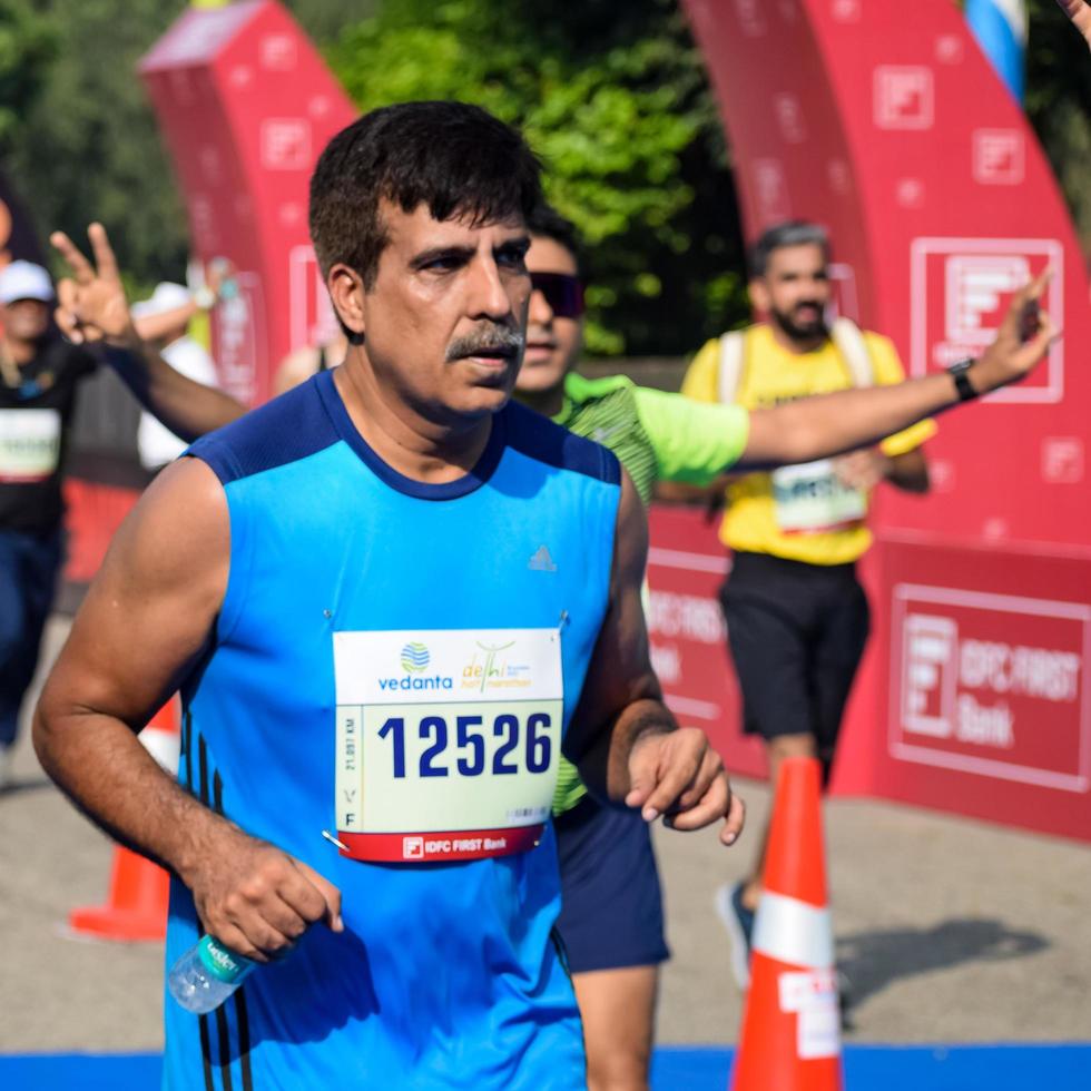 nueva delhi, india - 16 de octubre de 2022 - carrera de media maratón de vedanta delhi después de covid en la que los participantes del maratón están a punto de cruzar la línea de meta, media maratón de delhi 2022 foto