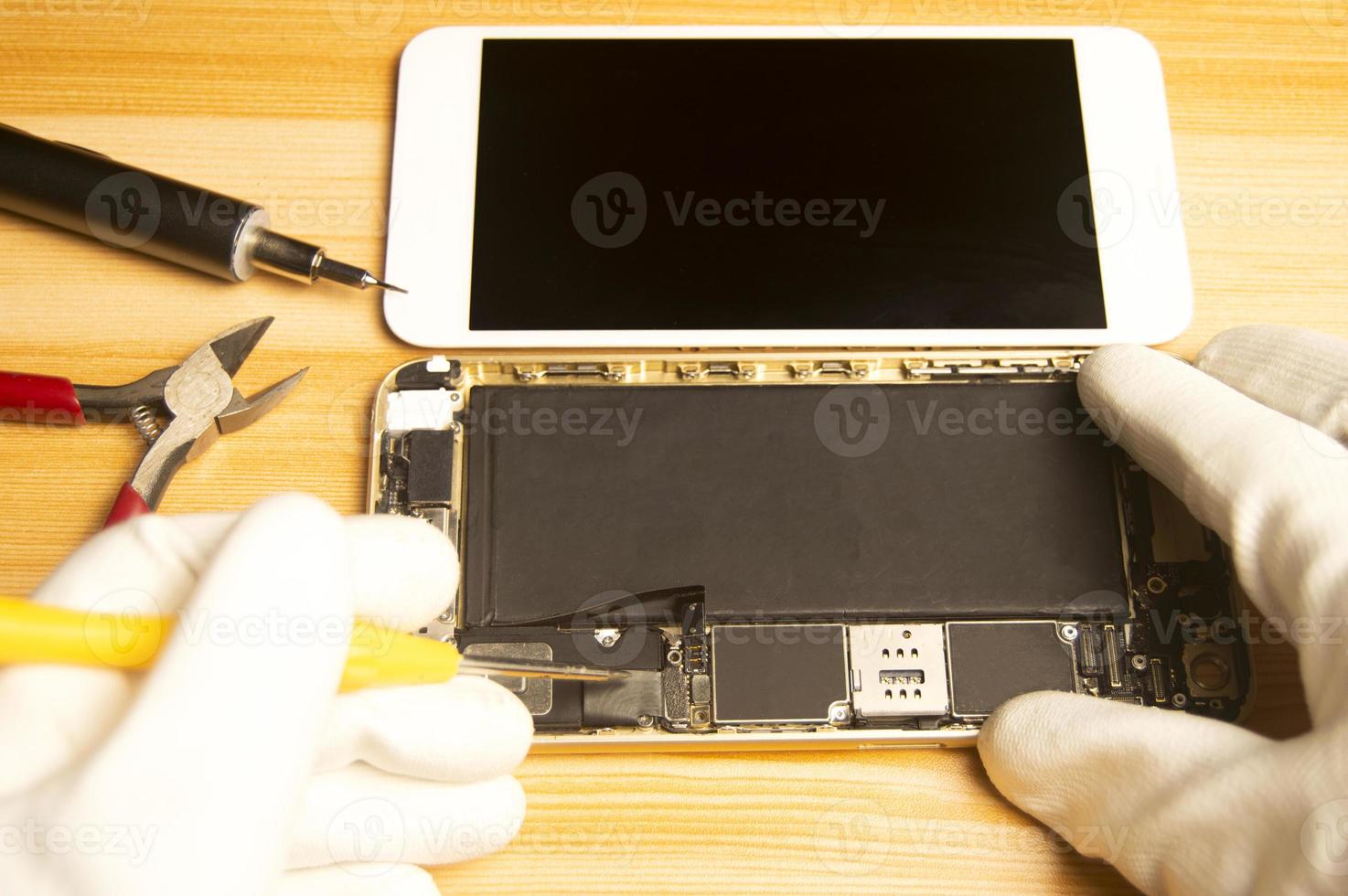 Top view of a technician repairing a smartphone photo