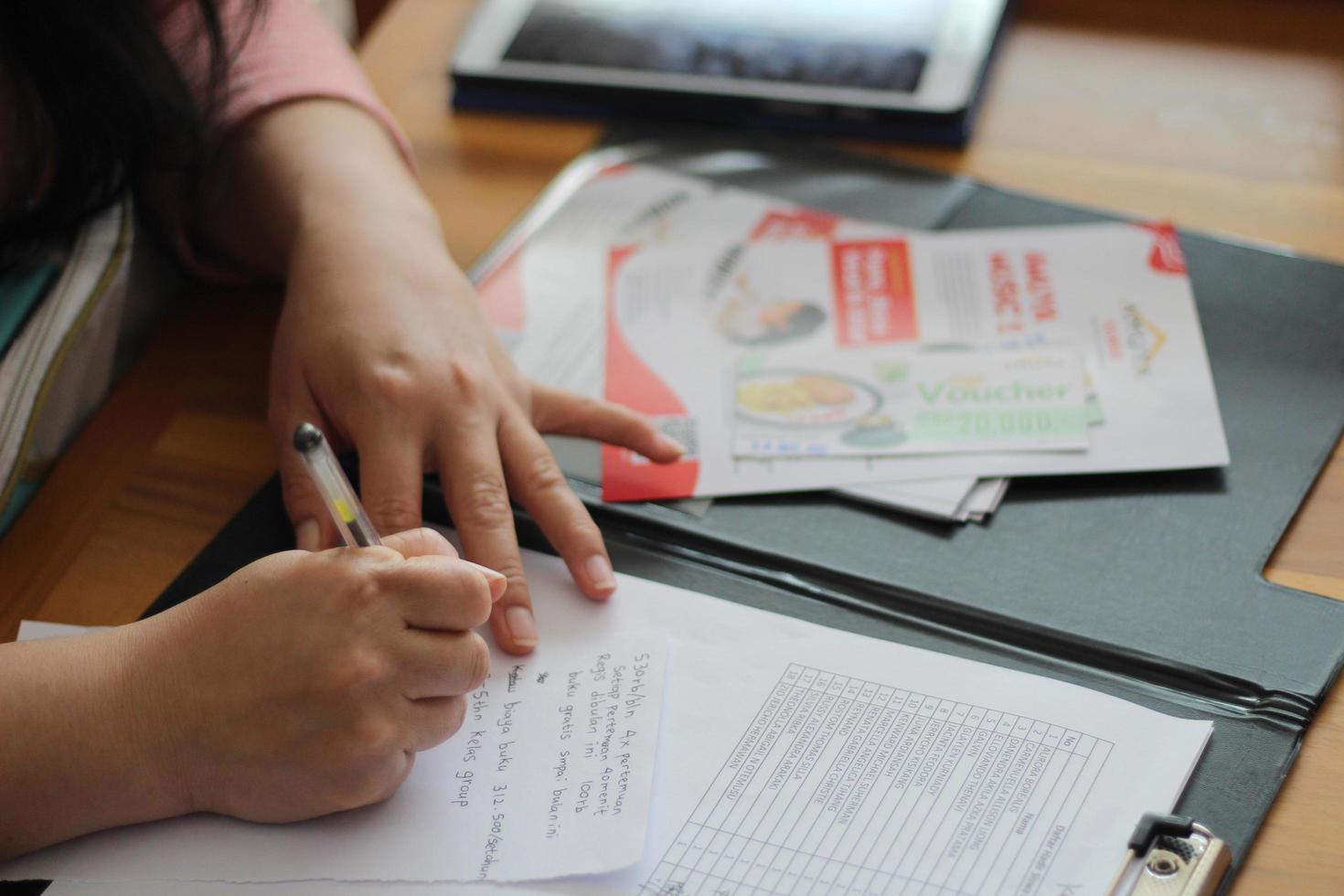 la recepcionista está grabando el registro de nuevos estudiantes en la mesa foto