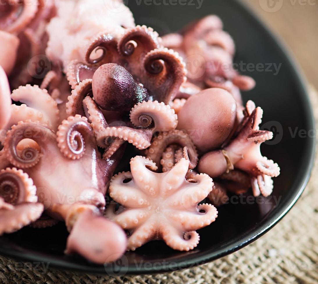 pulpo pequeño hervido en un plato foto