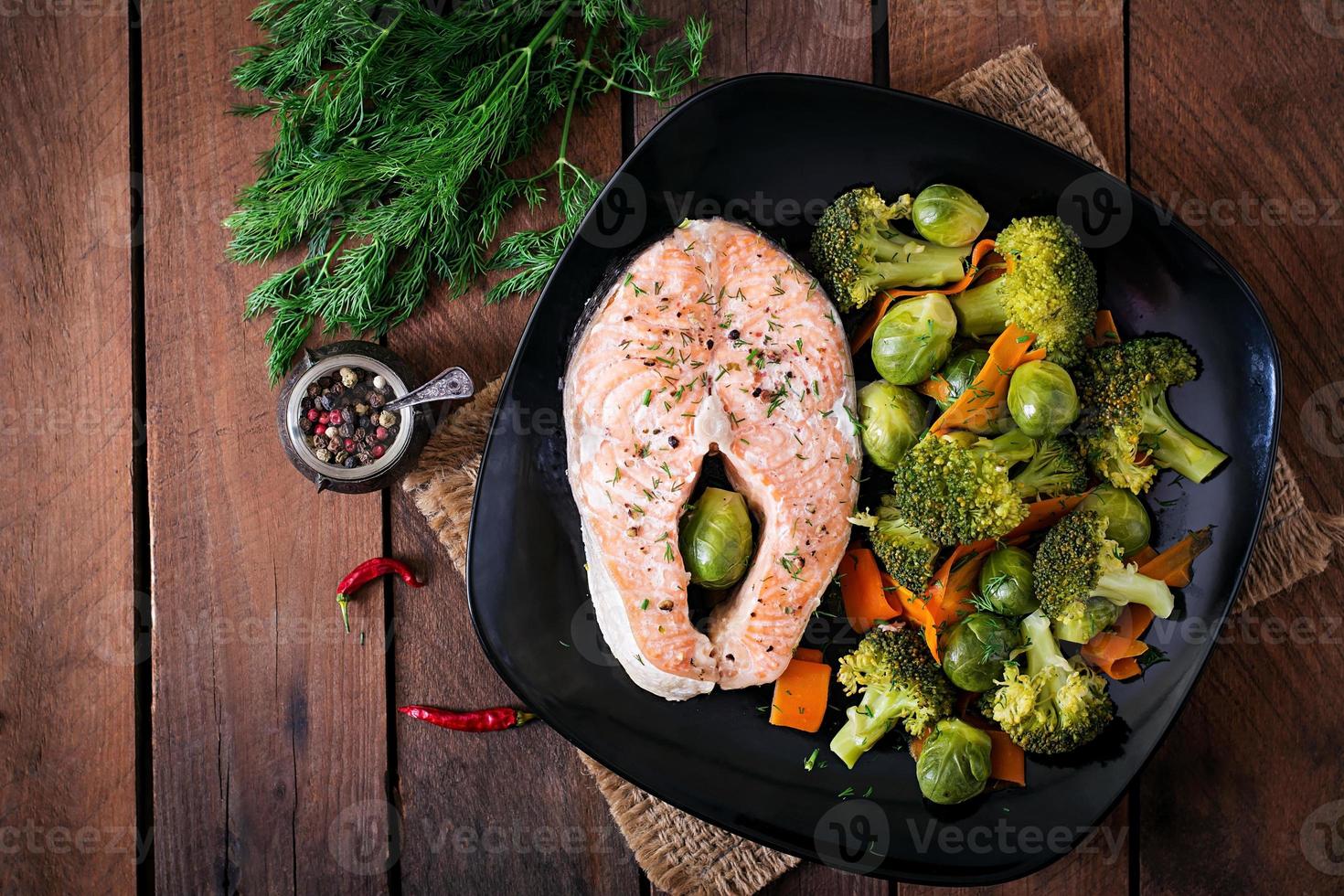 Cooked on steam salmon steak with vegetables. Top view photo
