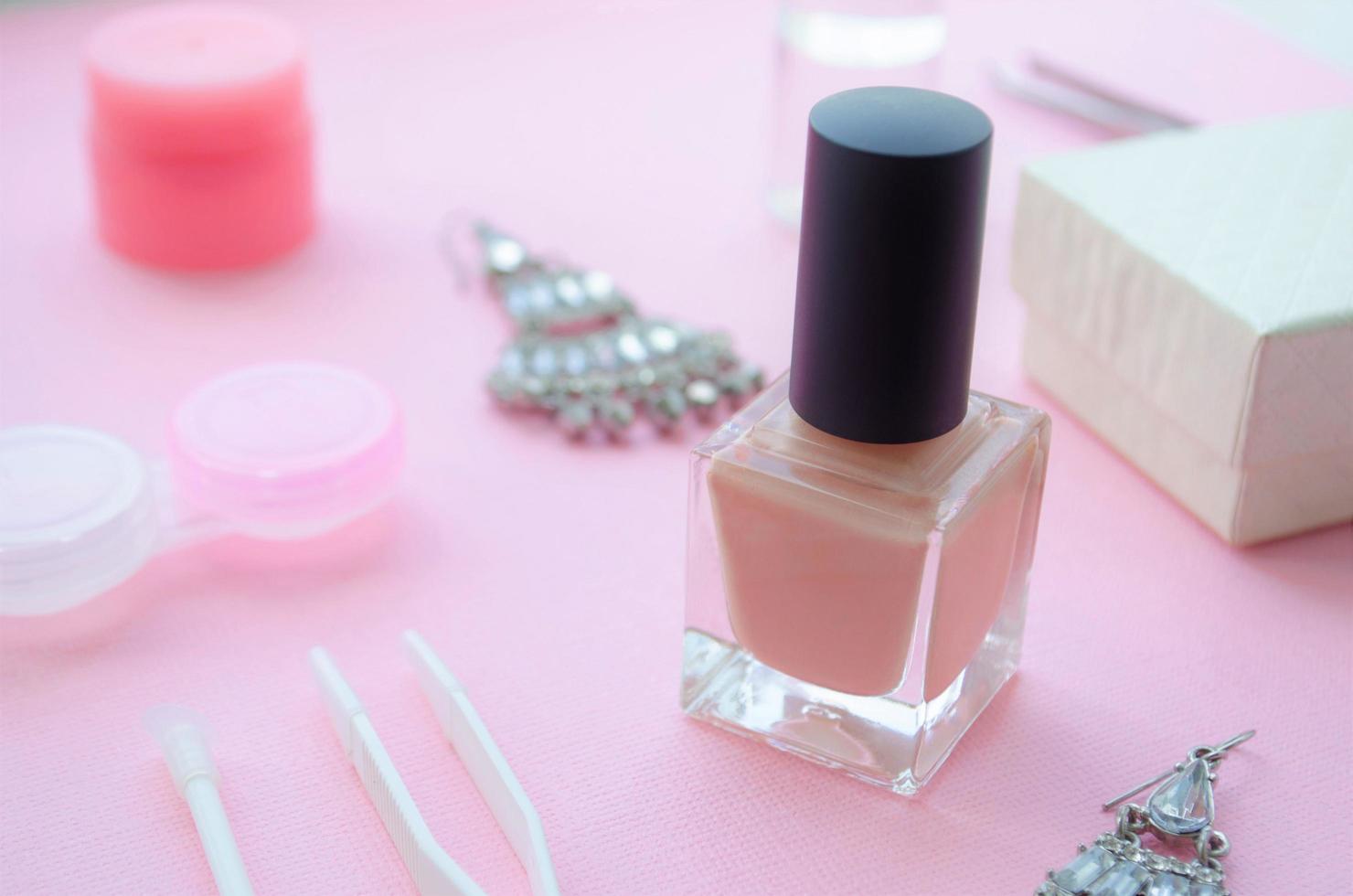 Nail polish on pink background. Pastel color nail polish. Light pink nail polish. photo