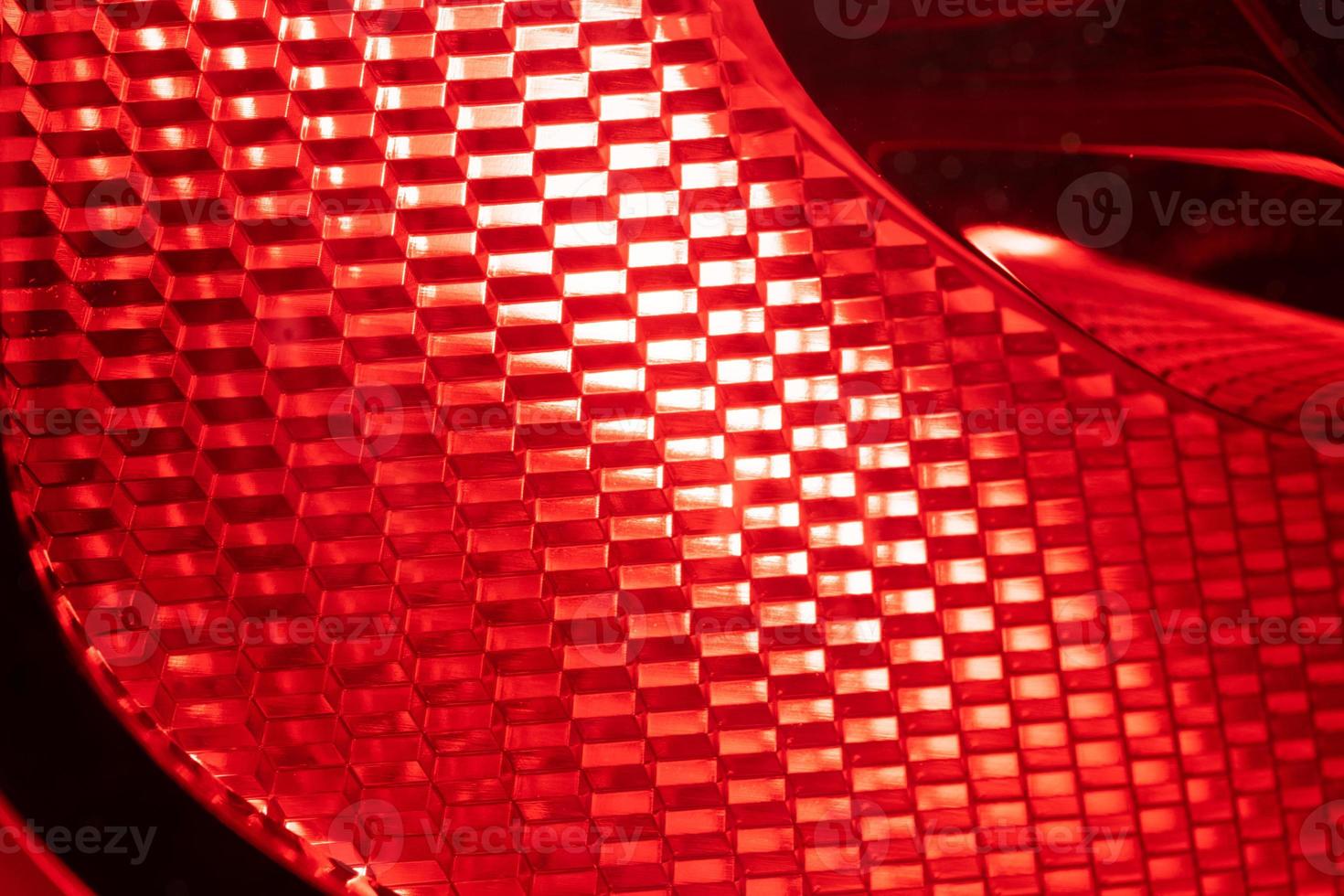 fondo rojo - detalle de una luz roja de advertencia de tráfico. el conjunto de luces de freno de un automóvil moderno foto