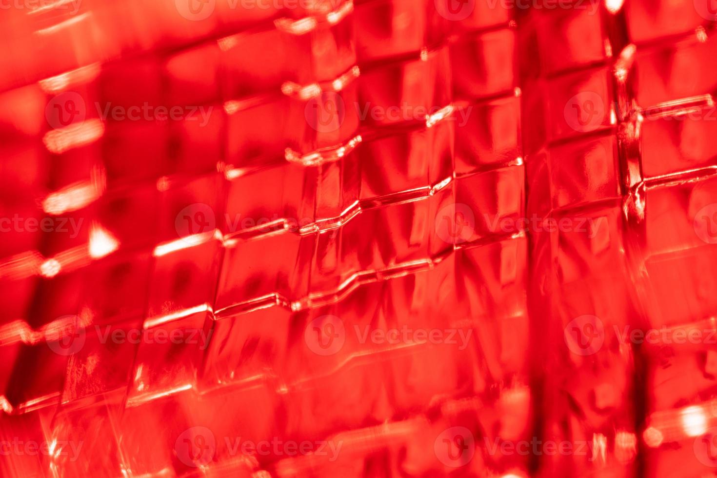 red background - detail of a red traffic warning lamp. The brake light assembly of a modern automobile photo