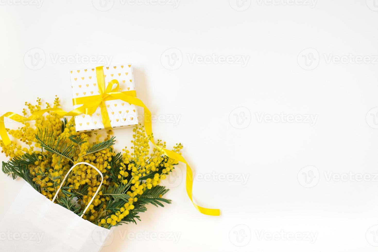 Yellow mimosa flowers frame with gift box. Womans day, easter , spring composition. Top view with copy space photo