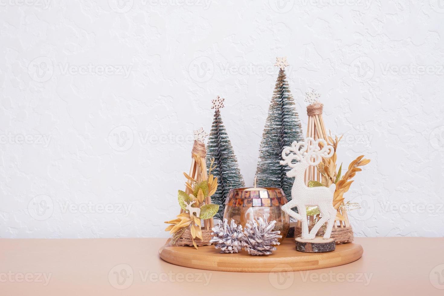 Christmas New year still life composition from deer and Christmas trees in home interior. Xmas candle and decorations photo