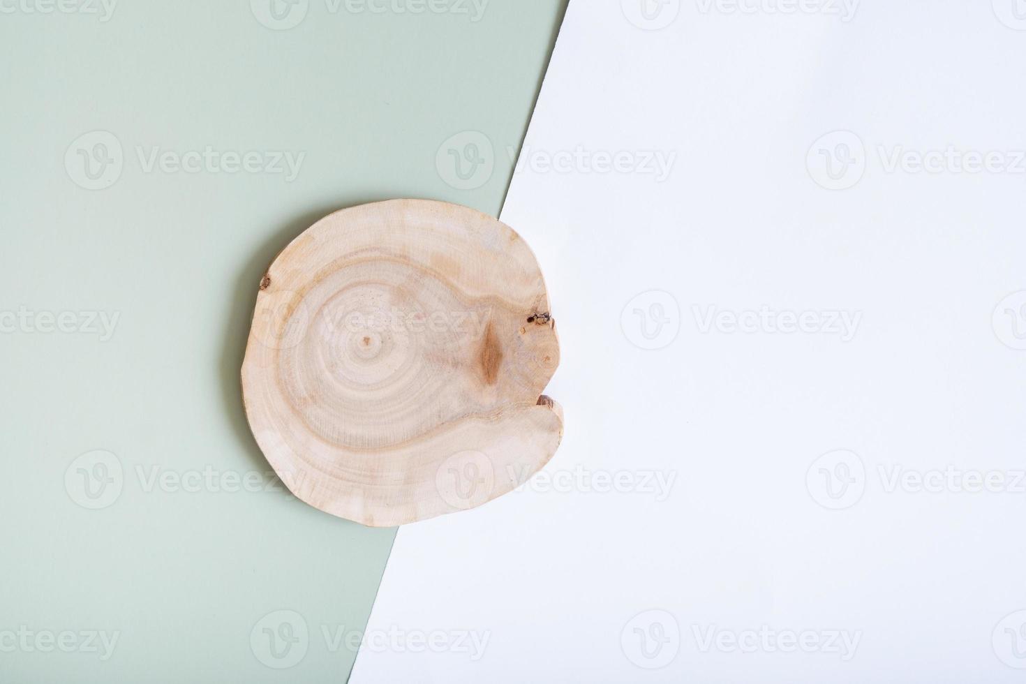 Wooden slice as podium or pedrstal top view, flat lay on colored background with nature decoration. Natural podium or pedestal mock up photo