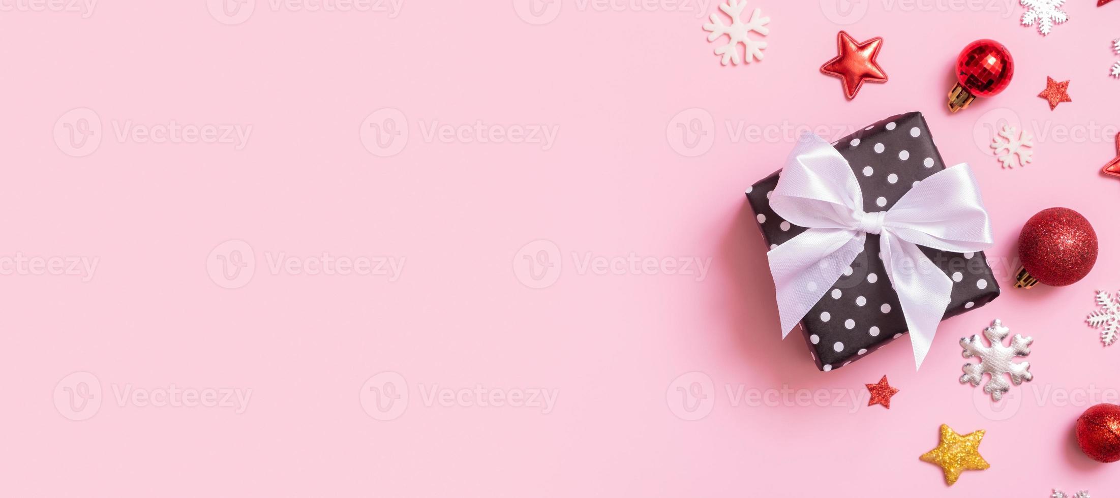 Christmas banner with present flat lay on a pink background. Top view xmas gift box with decorations. photo