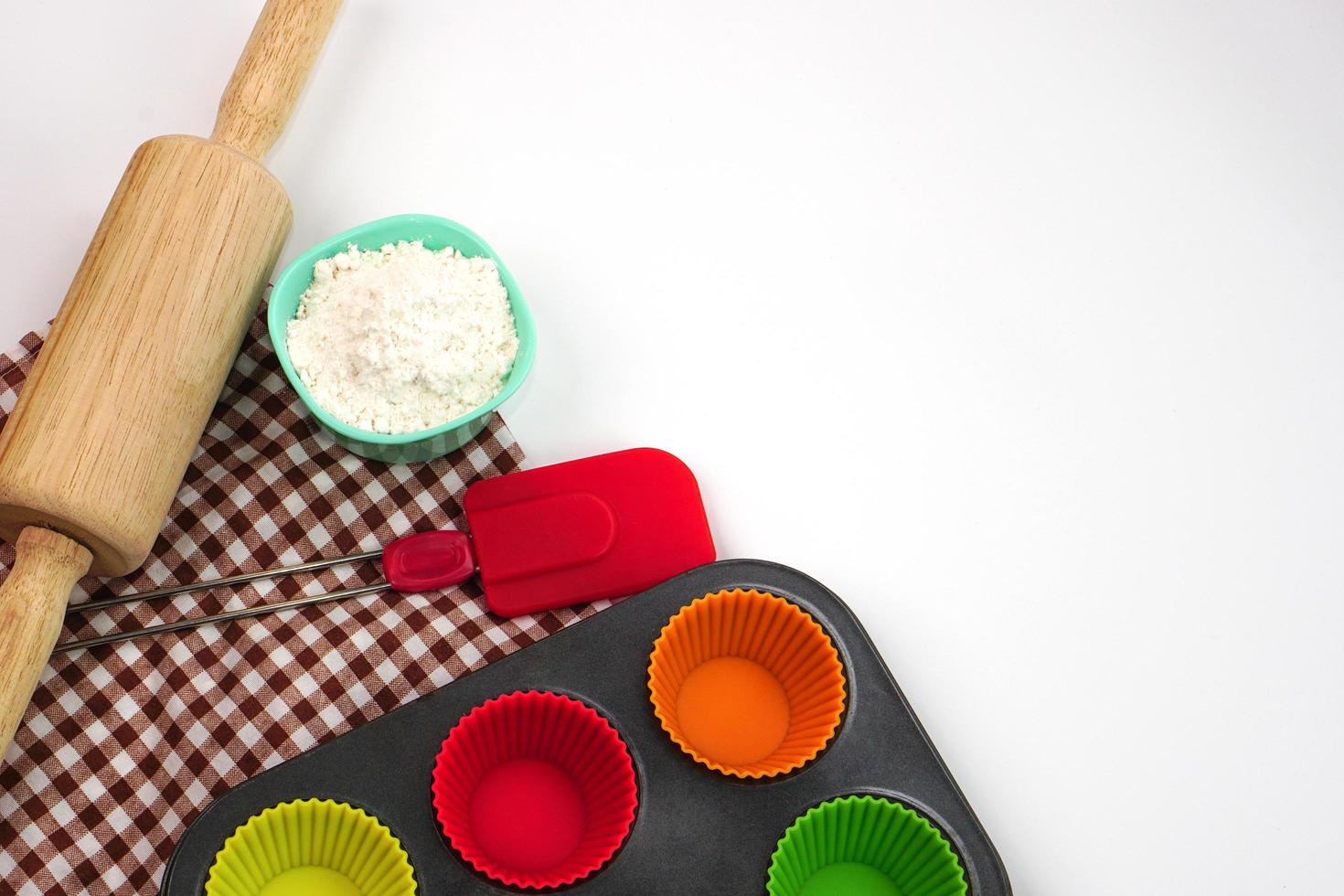 Top view kitchenware wooden rolling pin, wooden spatula and egg beater on white background. Materials or kitchen equipment for bakery. photo