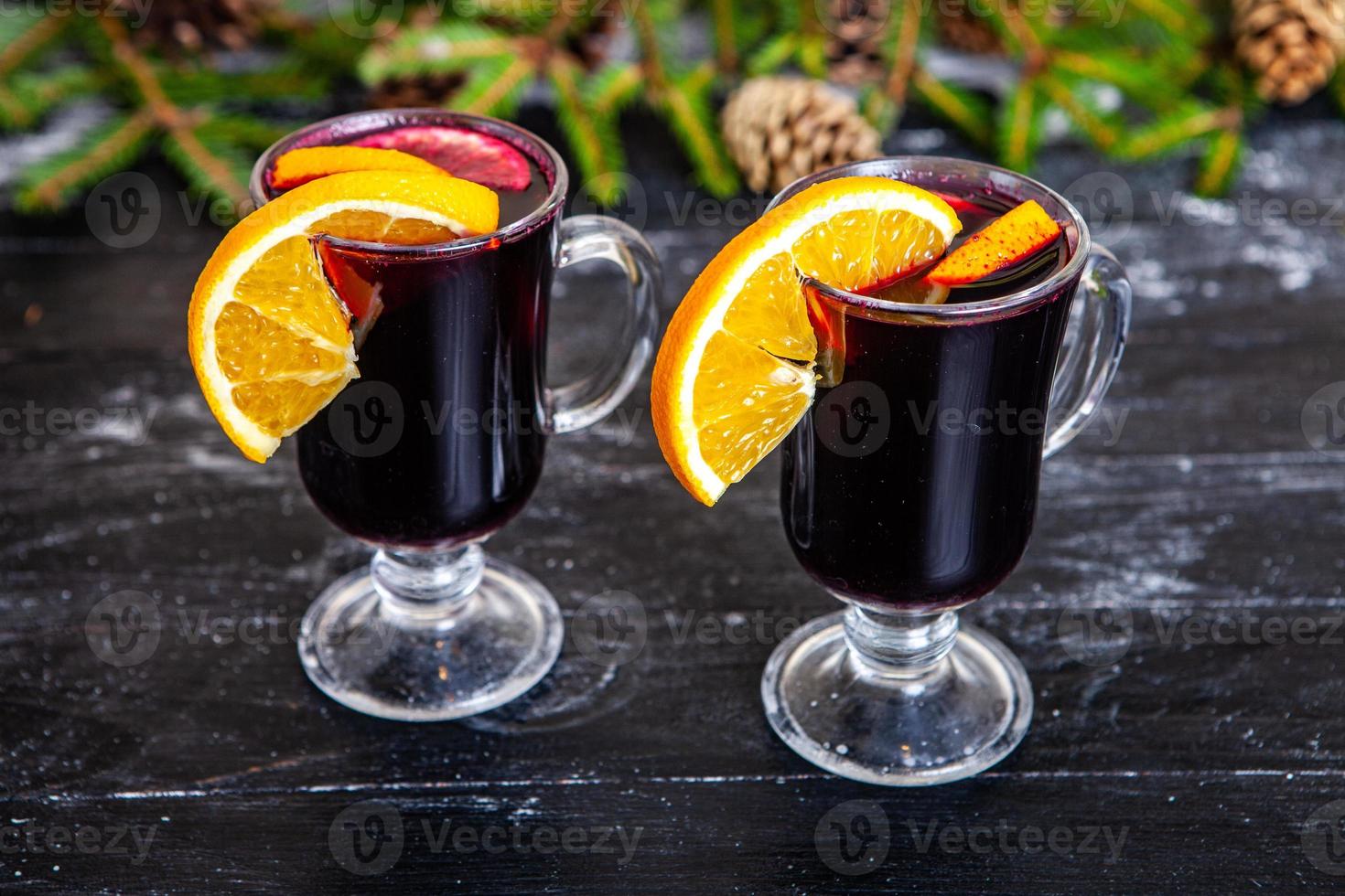 vaso de delicioso glintwein o vino caliente caliente, canela, hilo sobre fondo de madera vintage. foto