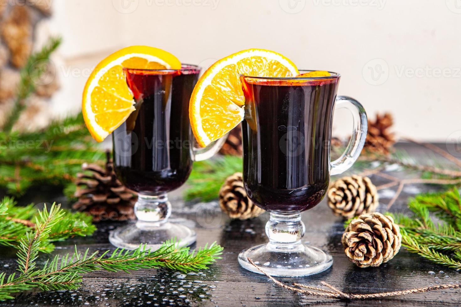 Glass of delicious glintwein or mulled hot wine, cinnamon, thread on vintage wooden background. photo