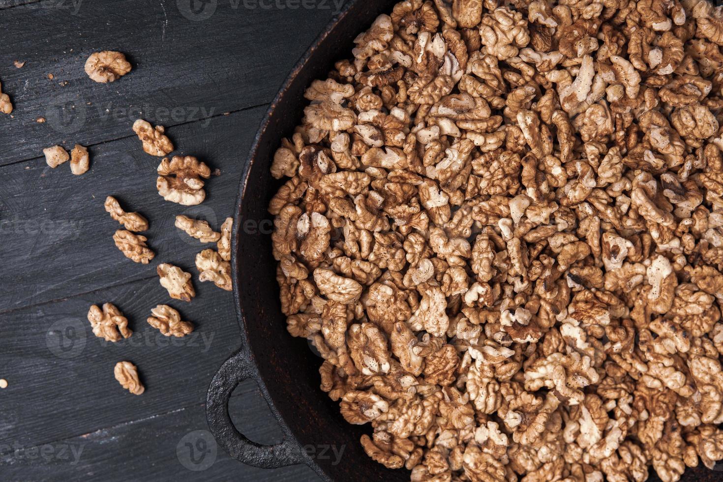 Walnut background. Peeled walnuts on a iron plate on black. walnuts a