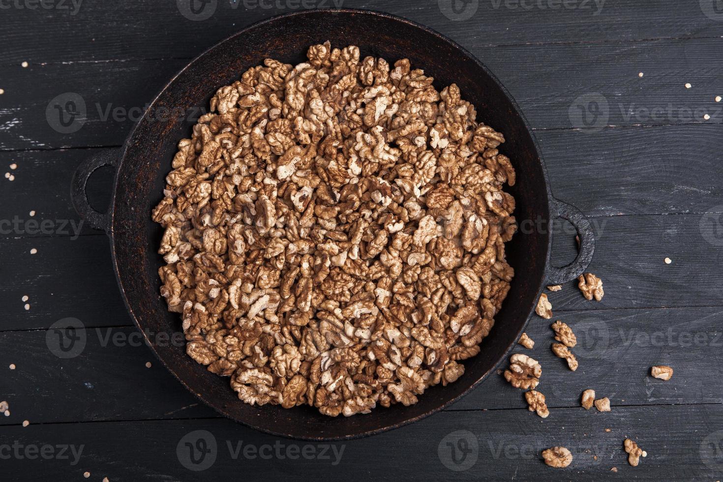 Walnut background. Peeled walnuts on a iron plate on black. walnuts a