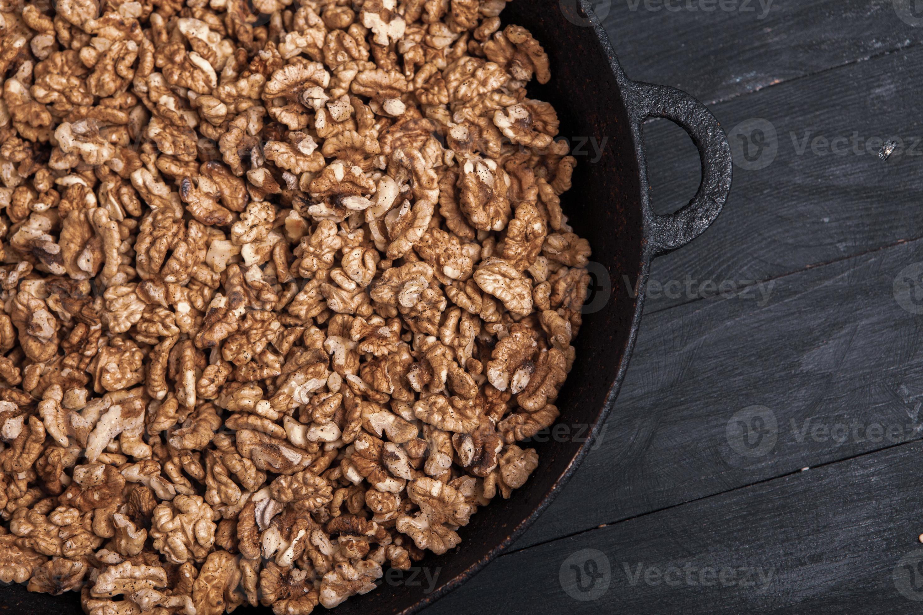 Walnut background. Peeled walnuts on a iron plate on black. walnuts a
