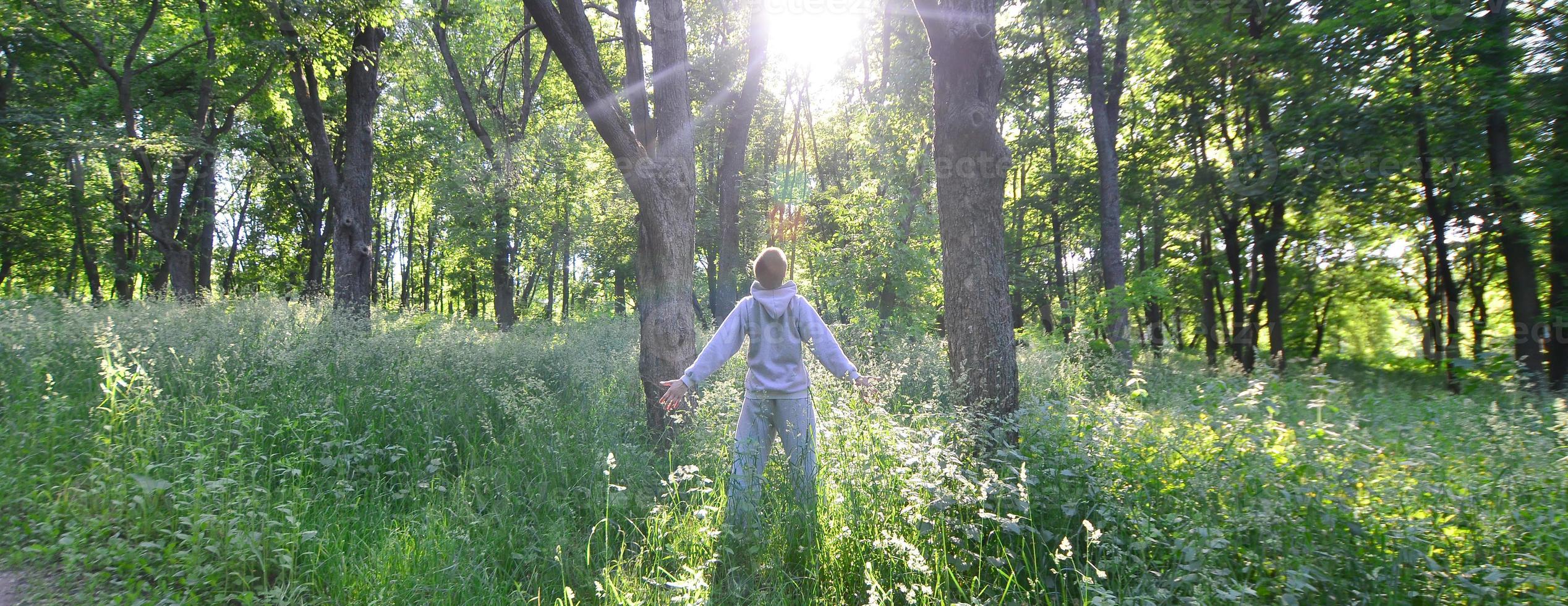 A young guy in a gray sports suit rejoices in the rising of the photo