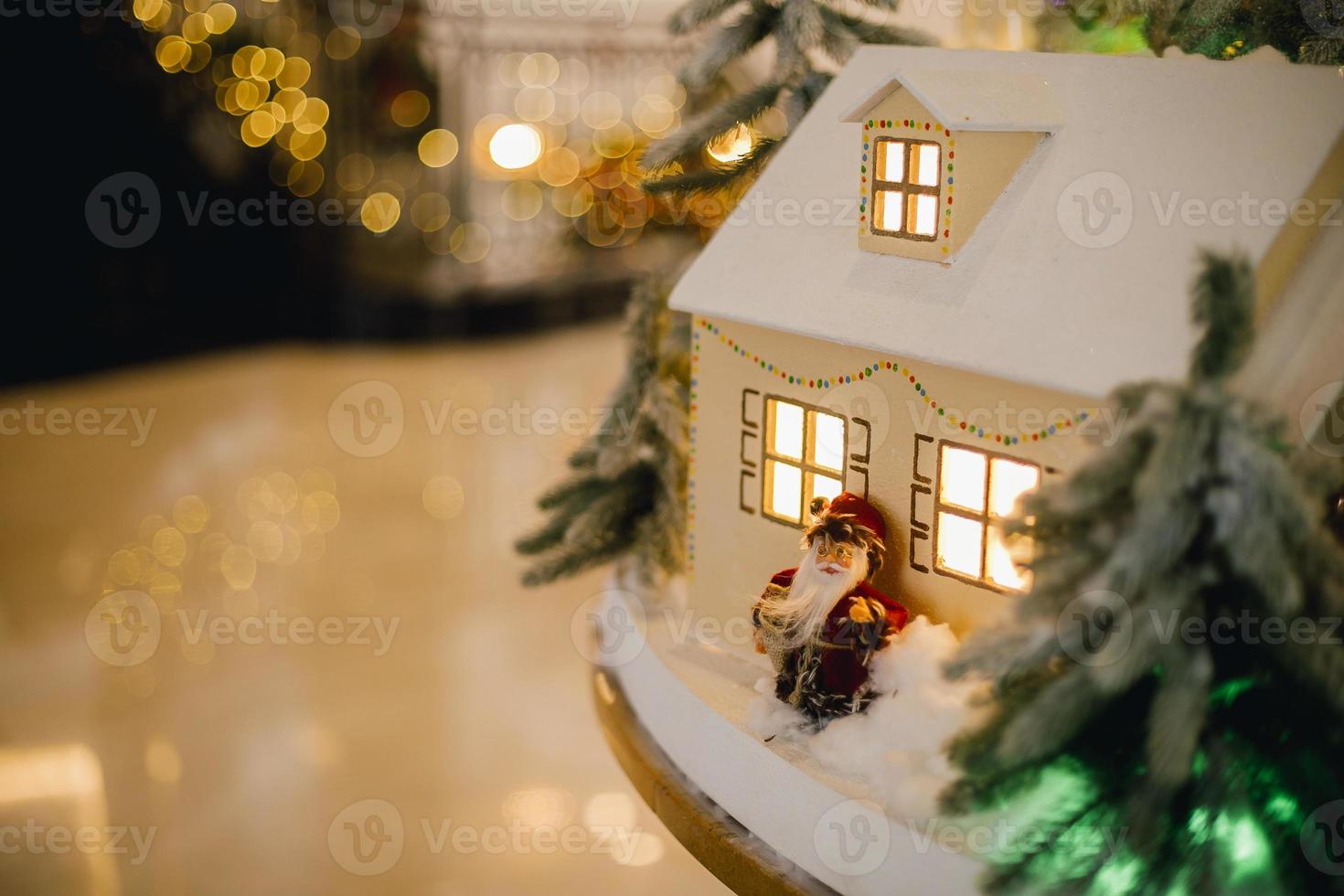 Festive installation in hotel. Houses with small Christmas tree and festive lights photo