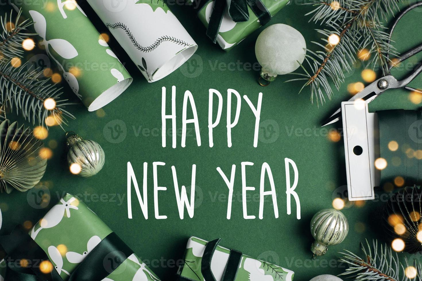Happy New Year Greeting card. Christmas decoration and wrapp present, fir tree on green background. Winter xmas holiday theme. Happy New Year. Flat lay photo