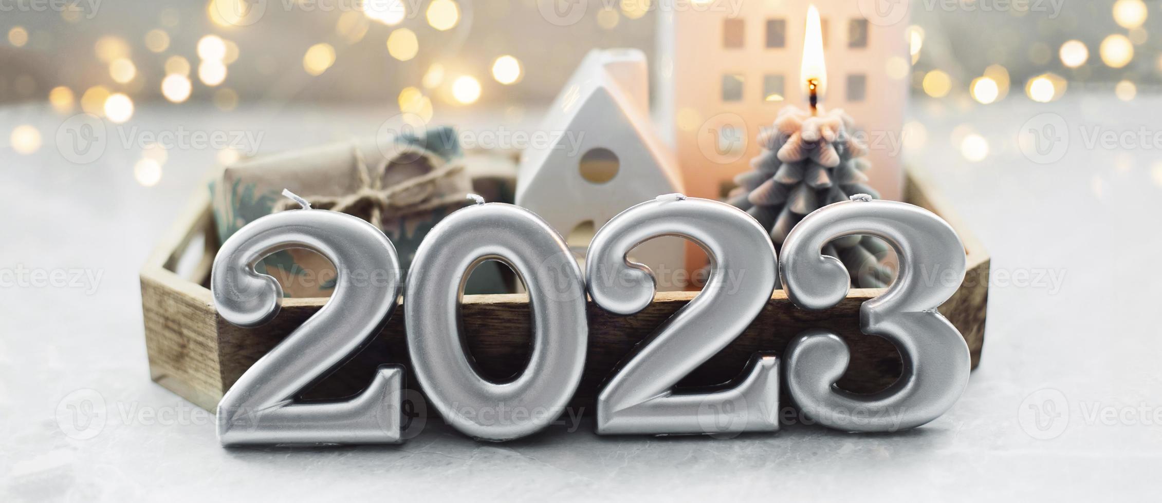 tarjeta de navidad y año nuevo. número 2023 sobre fondo de vacaciones. luces de navidad bokeh de fondo. postal de vacaciones. concepto de tarjeta de feliz año nuevo 2023 foto