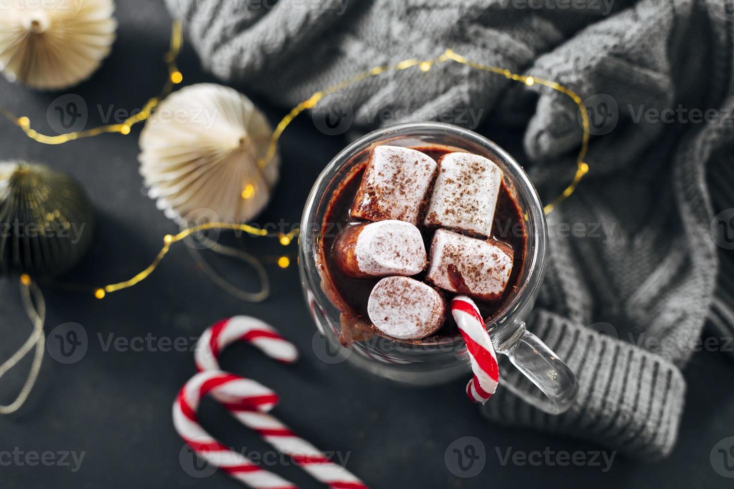 Glass with hot chocolate with marshmallow on dark blue background. Top view. photo