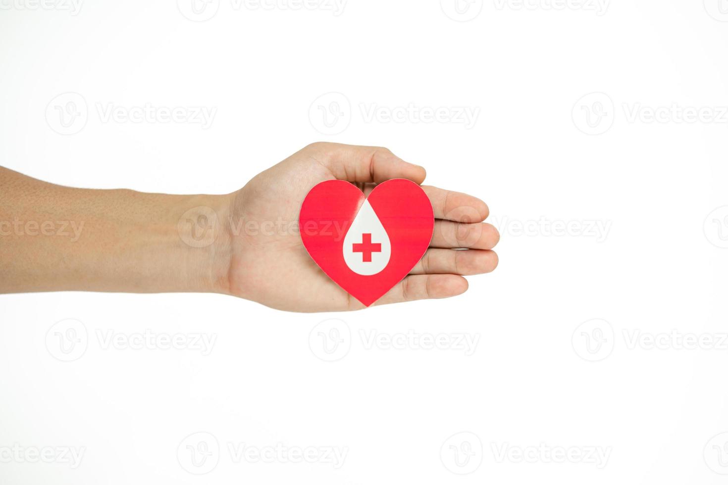 manos sosteniendo el corazón por dar vida corte de papel sobre fondo blanco, transfusión de sangre, día mundial del donante de sangre. concepto de donación de sangre foto