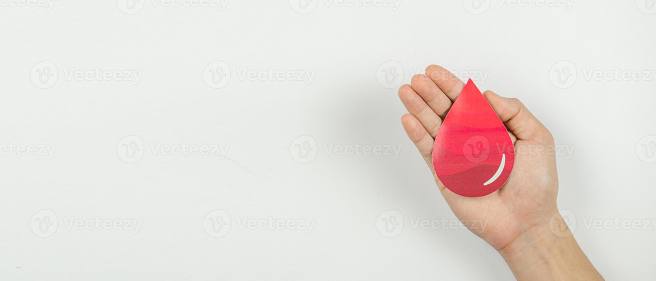 Hands holding blood drop paper cut on white background, Blood transfusion, World blood donor day. Blood Donation and Saving life Concept photo