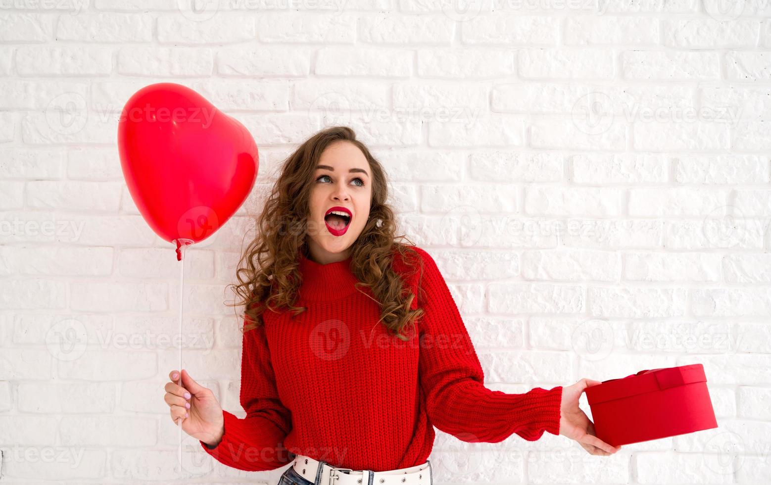 feliz mujer sorprendida con regalo y globo. concepto de día de la mujer o de san valentín. foto