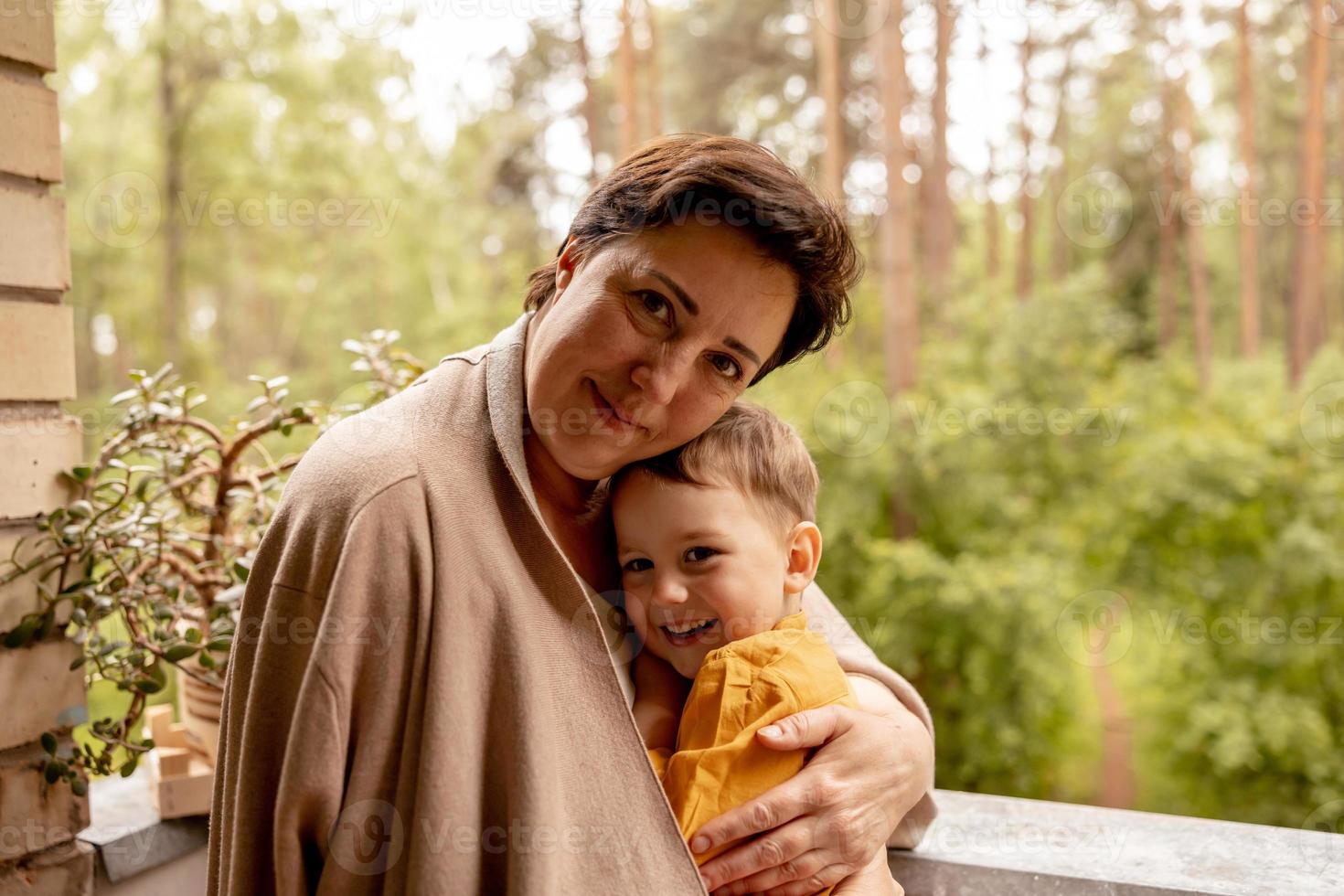 feliz abuela y nieto disfrutan del tiempo juntos. mujer positiva de mediana edad que pasa tiempo con un pequeño y lindo nieto, divirtiéndose. Abuela de 50 años con nieto. familia multigeneracional. foto