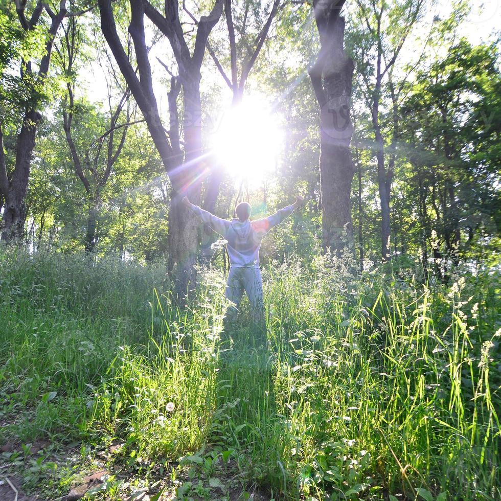 A young guy in a gray sports suit rejoices in the rising of the photo