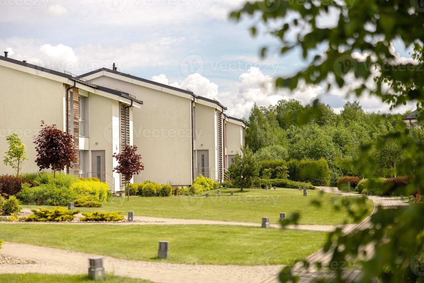 fila de cabañas modernas. hilera de casas unifamiliares a estrenar. diseño moderno de residencias de vida urbana con patios privados, acabados sofisticados, nuevo desarrollo. instalaciones verdes al aire libre, césped foto