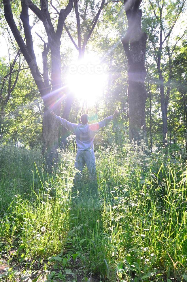 A young guy in a gray sports suit rejoices in the rising of the photo