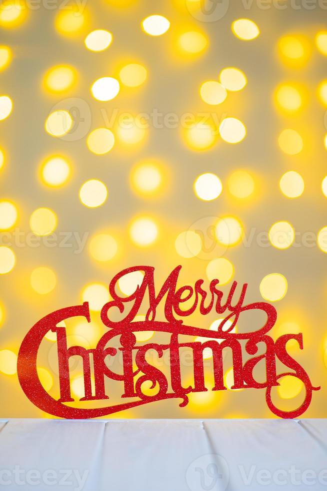 Red wooden glitter lettering Merry Christmas on yellow blurred light bokeh background. photo