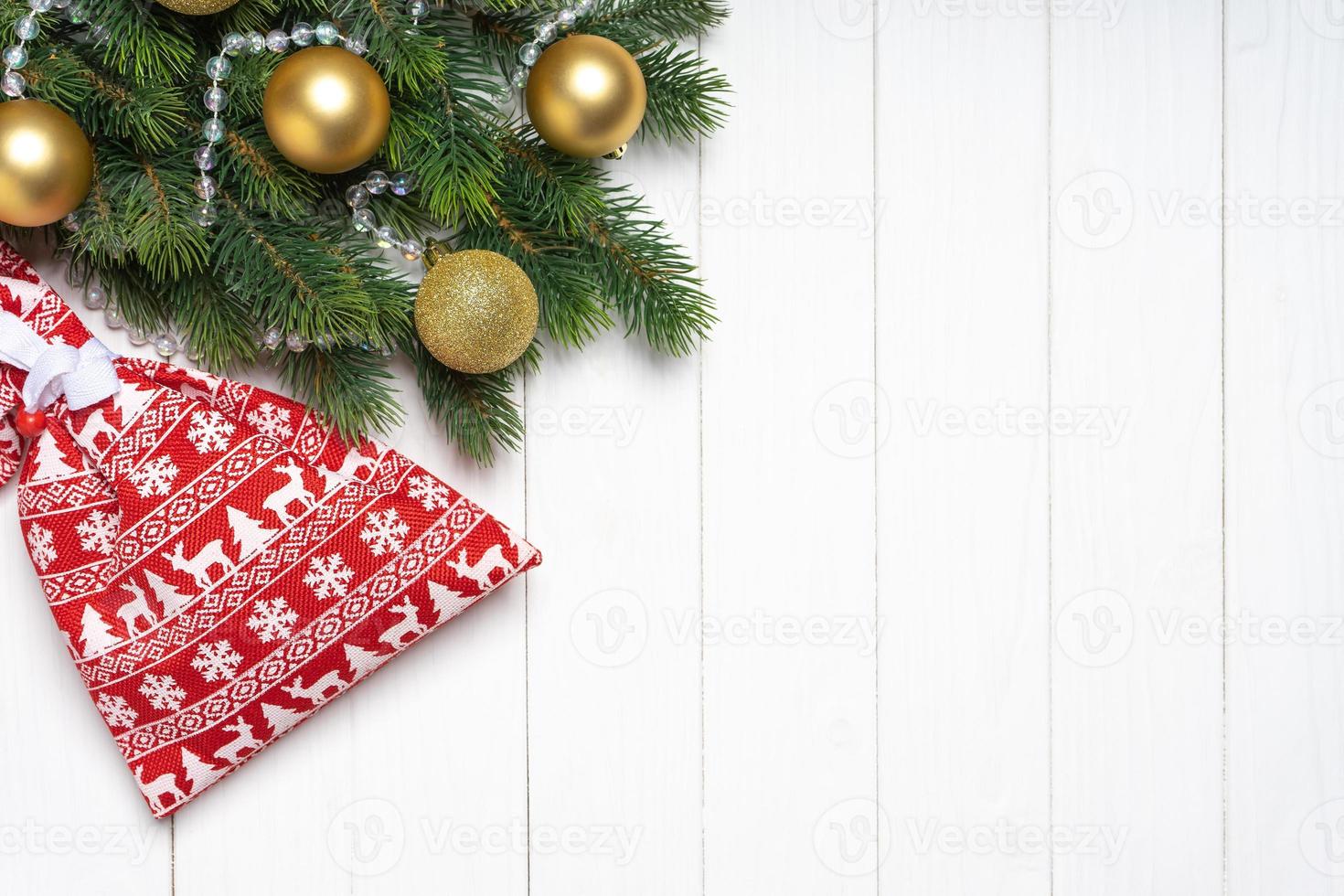 Christmas background with decorated fir tree and red gift bag. Top view, flat lay with copy space photo