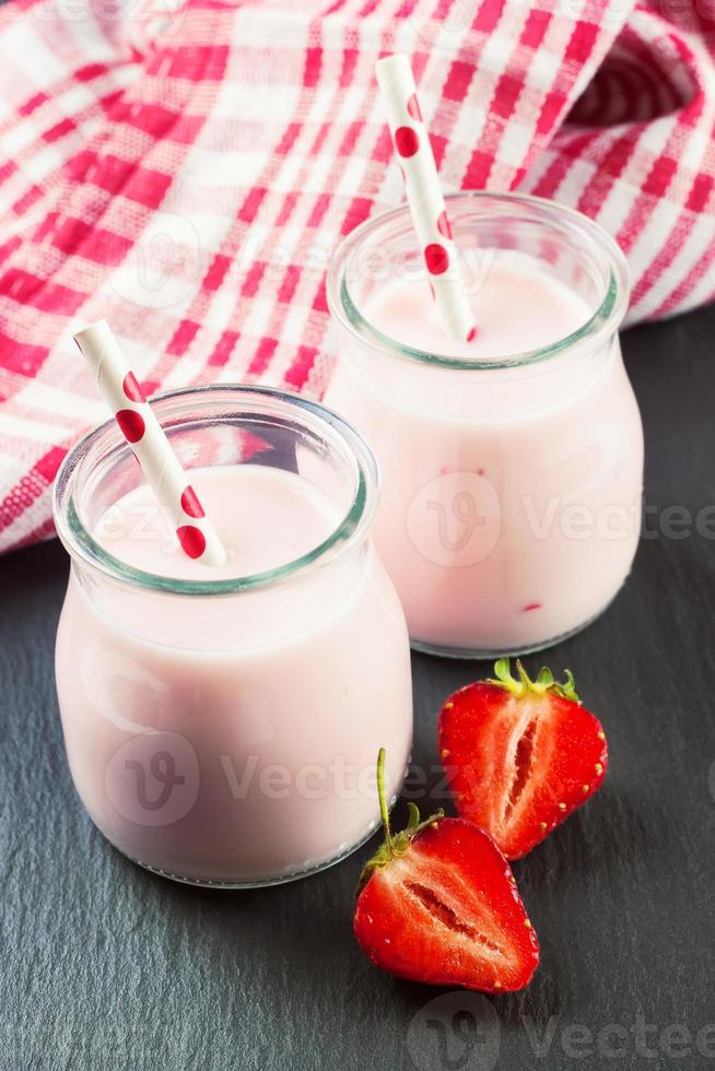 batido de fresa en el frasco de vidrio sobre fondo de pizarra negra foto