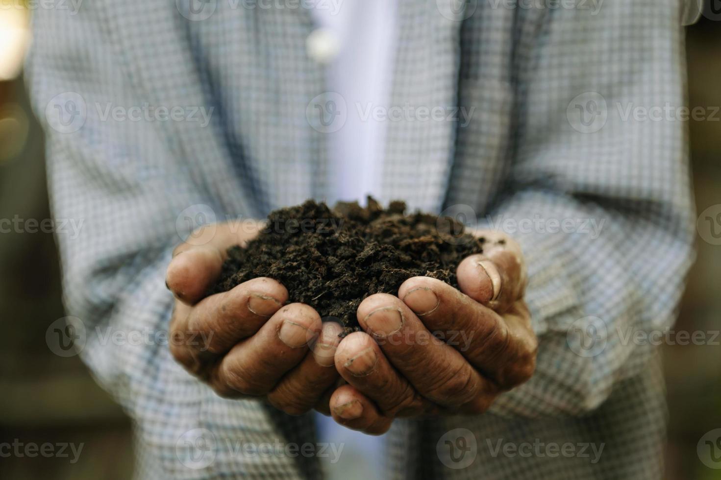 granjero sosteniendo tierra en primer plano de las manos. foto