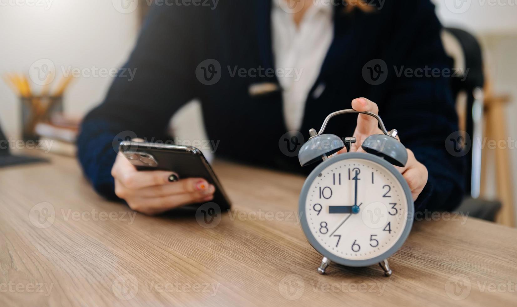 Alarm clock on the desk. Business working in modern office building or home at night using laptop. photo