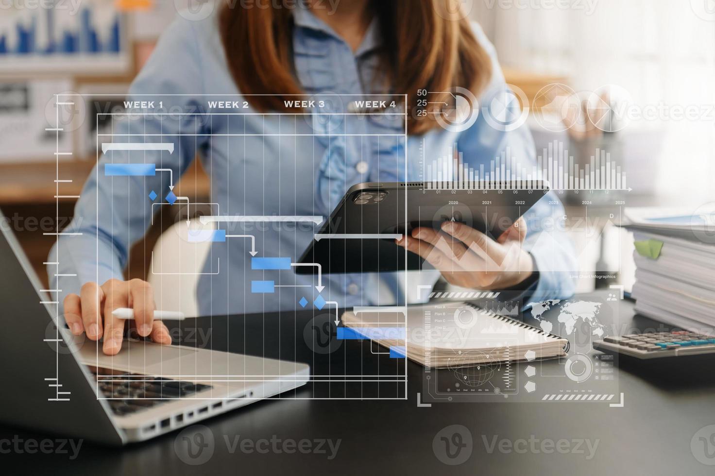 Businessman hand Project manager working and update tasks and Gantt chart scheduling virtual diagram.with smart phone, tablet and laptop in office. photo