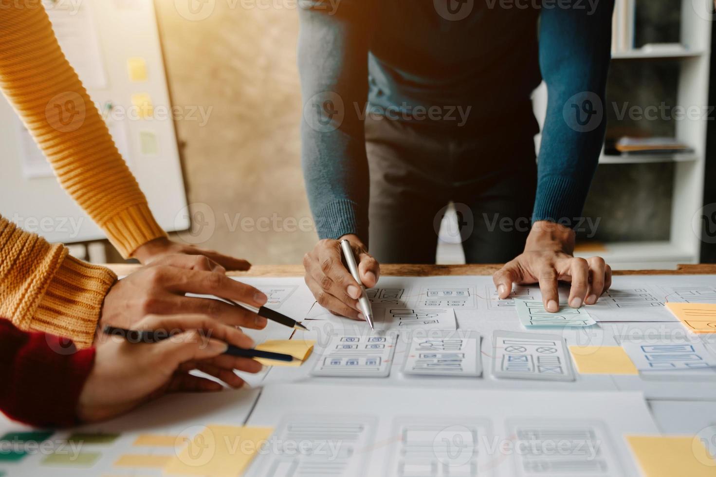 UX developer and ui designer brainstorming about mobile app interface wireframe design with customer breif and color code at modern office. photo